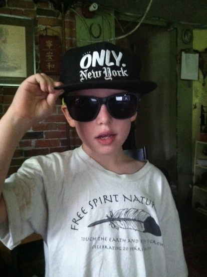 boy wearing hat and sunglasses posing for a po
