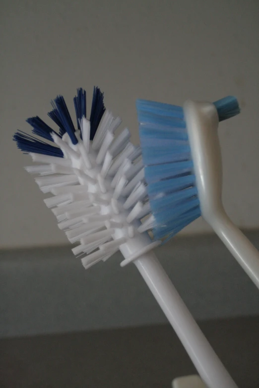 two different colored tooth brushes sitting on a stand