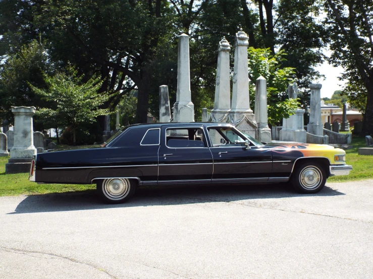 the black and yellow car is parked near the obelisk