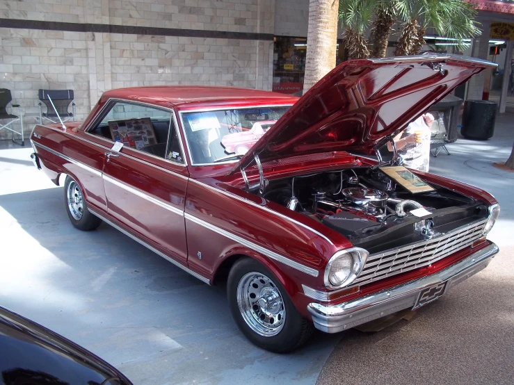 an old red car with its hood open