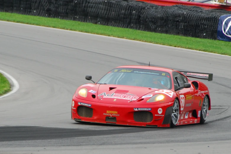 a red sports car on the road in an open track