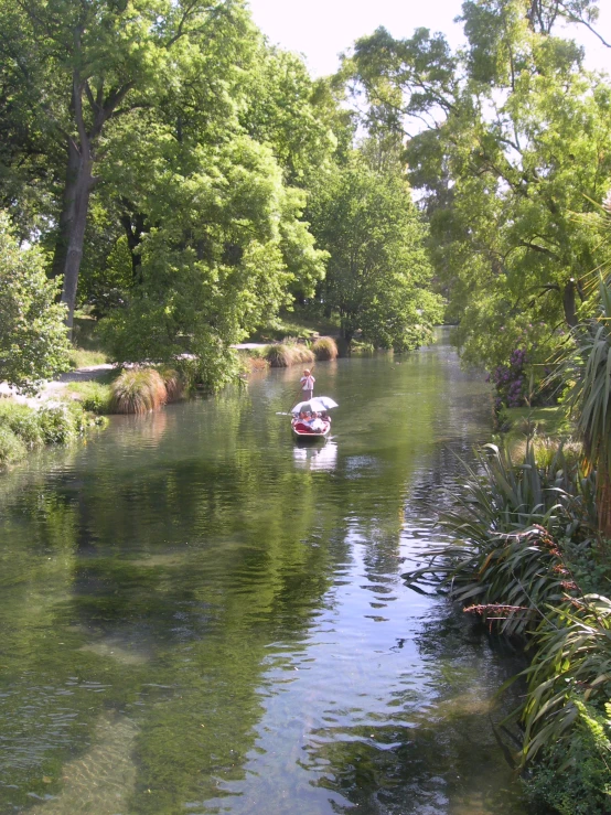 boats glide down a waterway in a city park