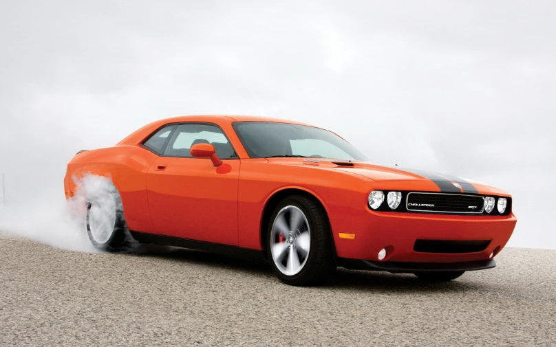 a fire orange muscle car rolling through the desert