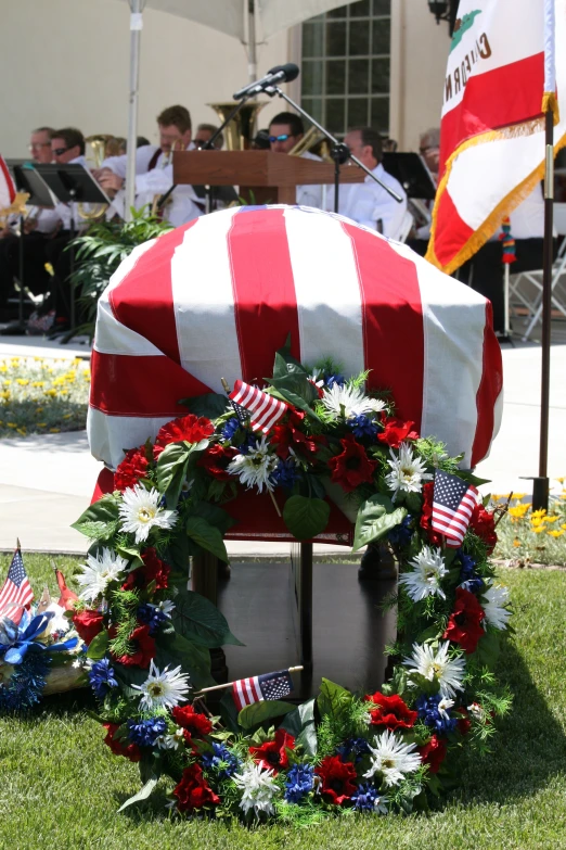 an american flag wreath is adorned with flowers