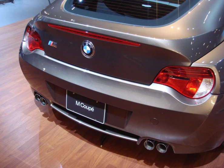 the rear view of a silver bmw coupe on display