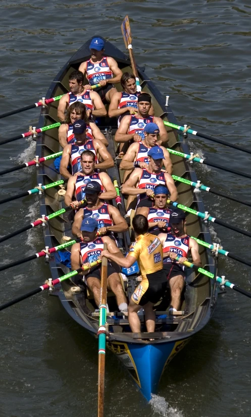 a bunch of people are on the boat with their oars