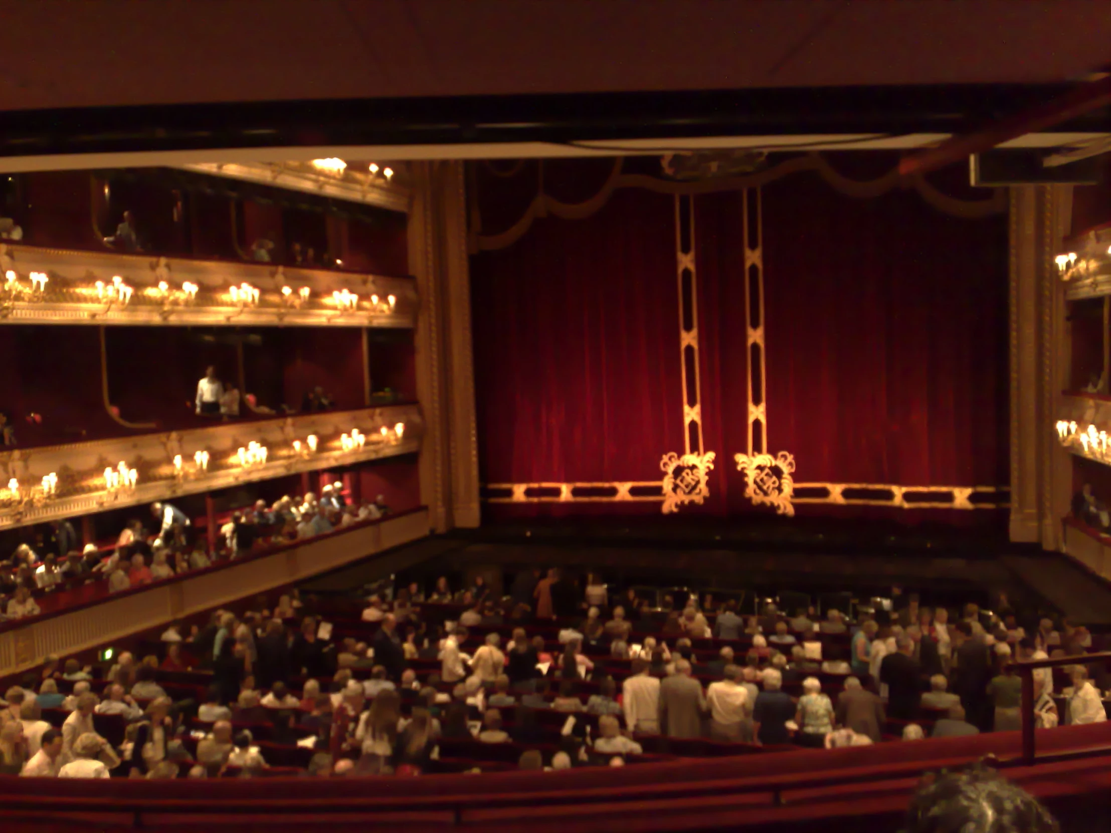 a theatre with several rows of seats and red curtains