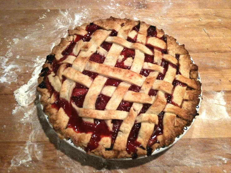 a pie covered in strawberry filling sitting on top of a table