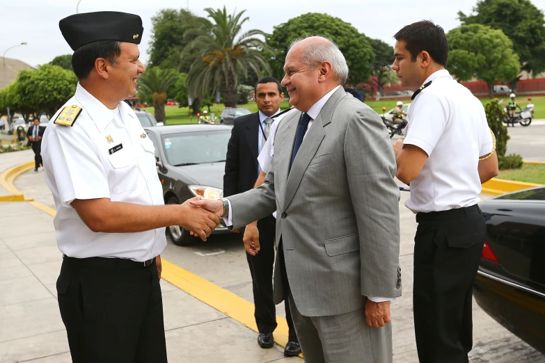 two men shaking hands with two other people