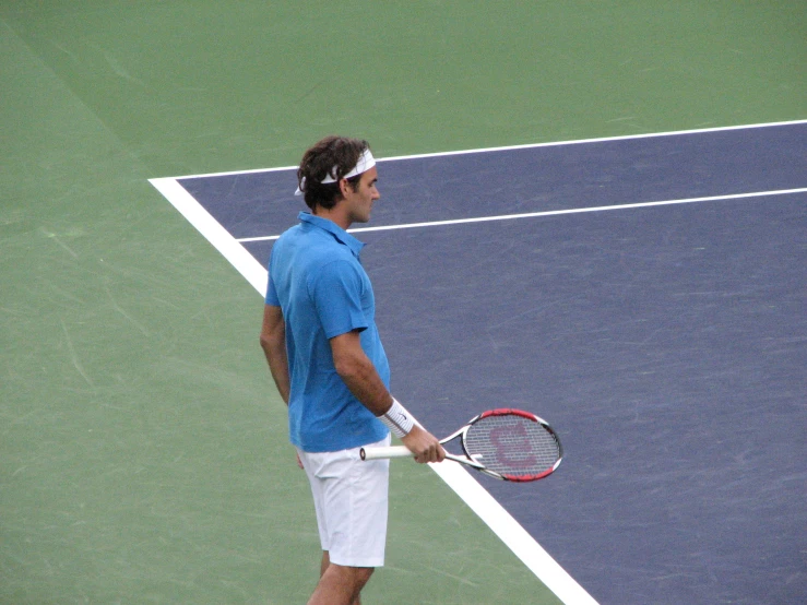 a man wearing white shorts holding a tennis racquet