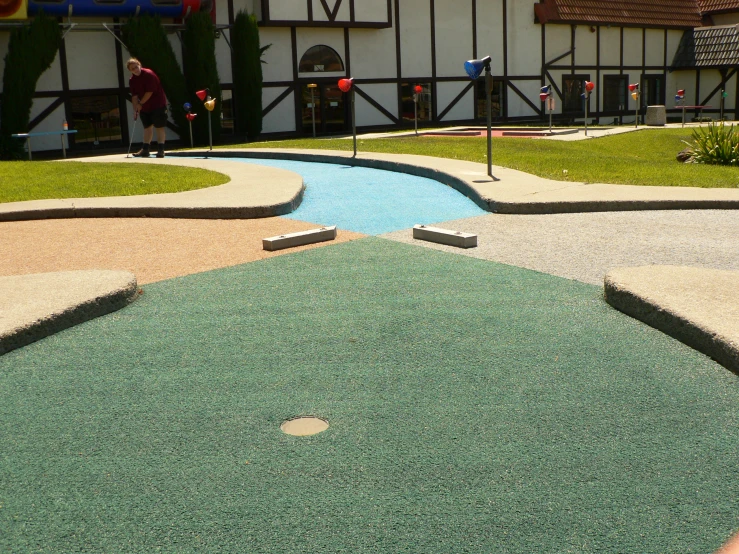 a building with green grass, some red and white flags and a yellow fire hydrant