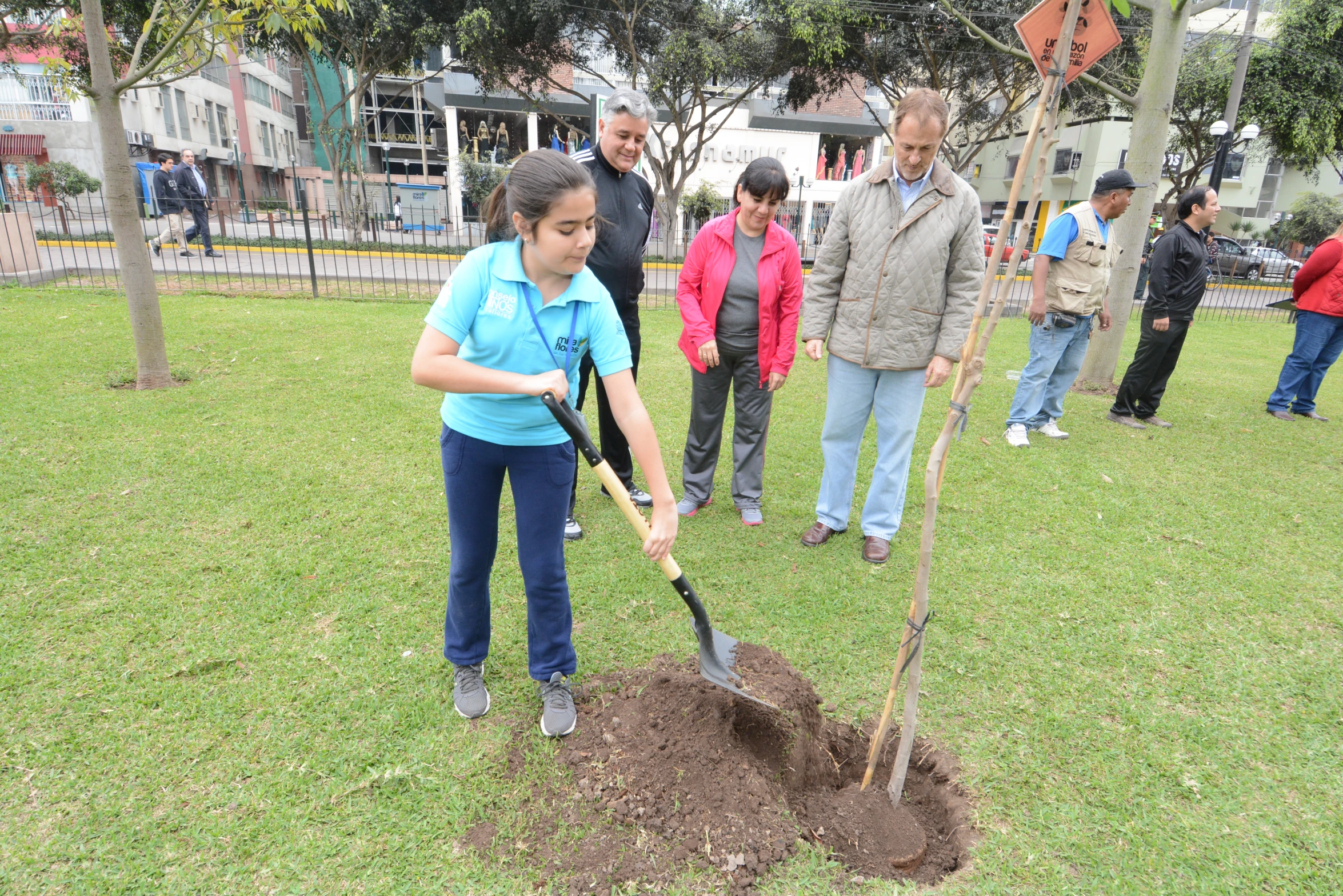 a little girl with a shovel digging in the soil