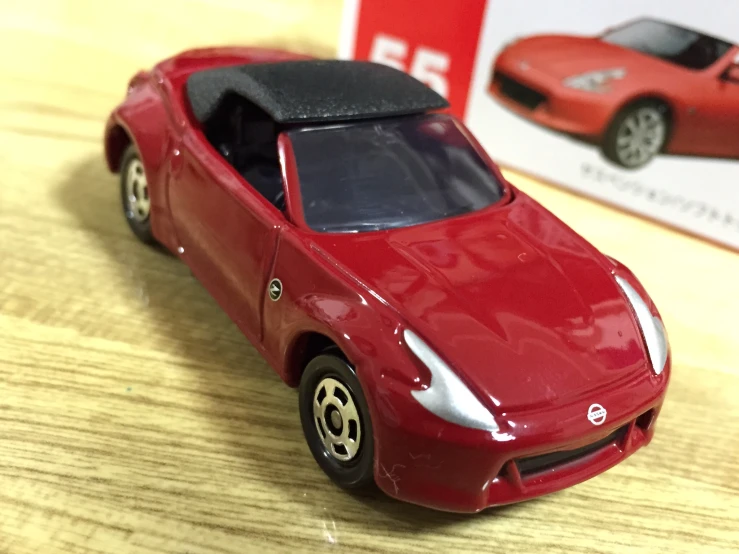 a toy car on the wooden table with a red box