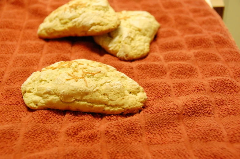 three white cookies are on a red towel