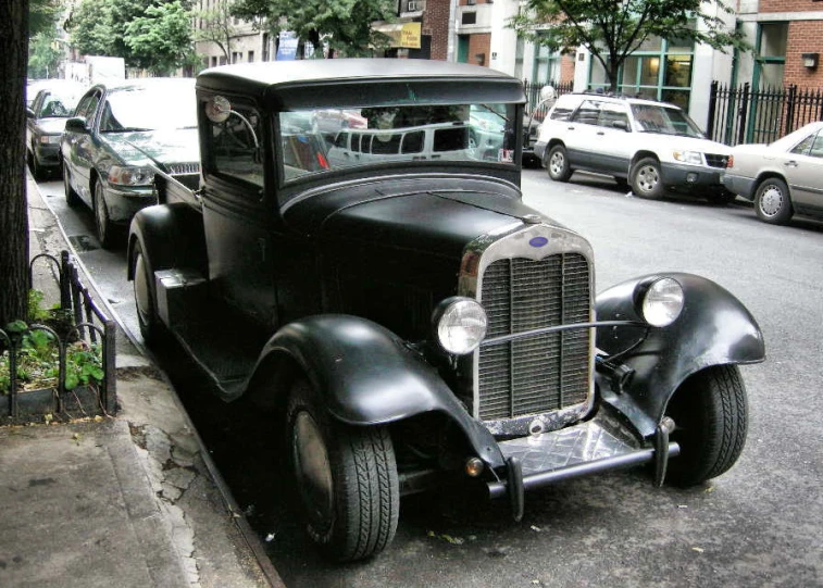 an old style automobile parked in front of another car