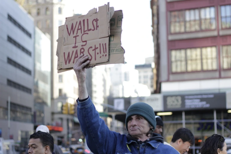 the man holds up signs while in the crowd