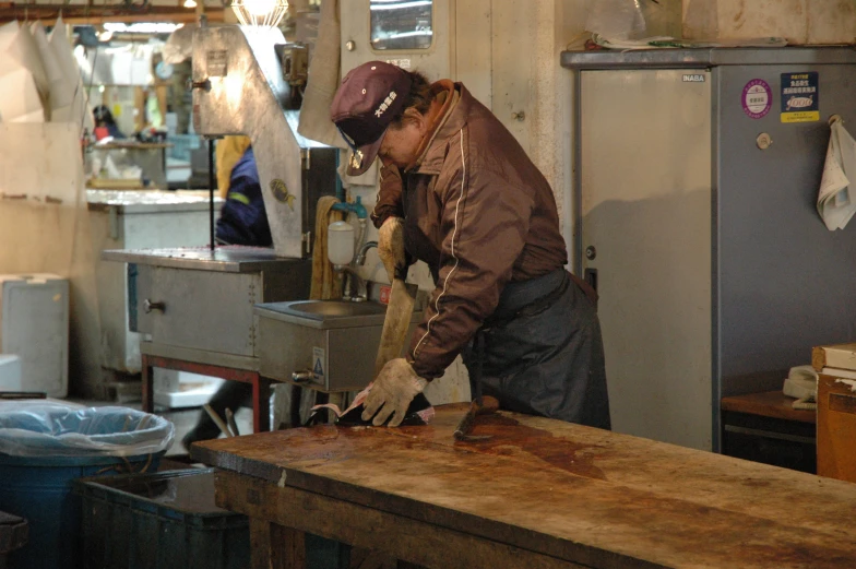 an industrial kitchen with a male blacksmith holding a tool