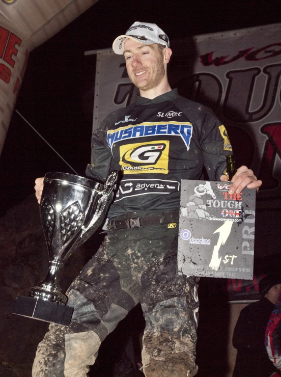 a man standing on a ramp holding a trophy