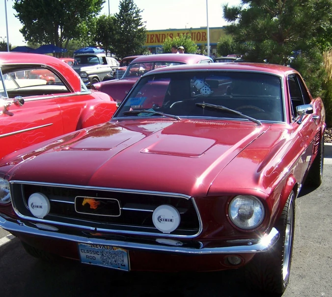 a red car parked in the street surrounded by other cars