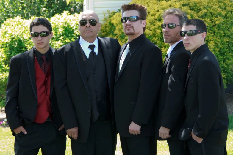 four young men dressed up and wearing sunglasses