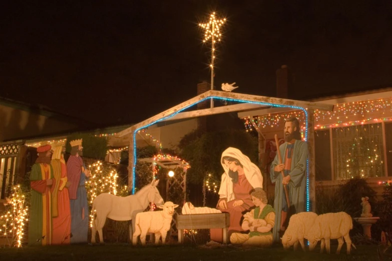 a nativity scene is displayed on a home in the evening