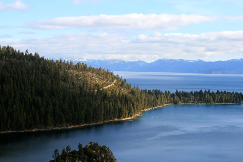 an island in the middle of a lake surrounded by mountains