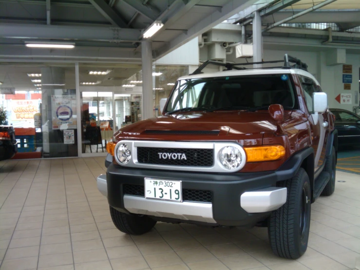 a red vehicle sits in the middle of the shopping mall