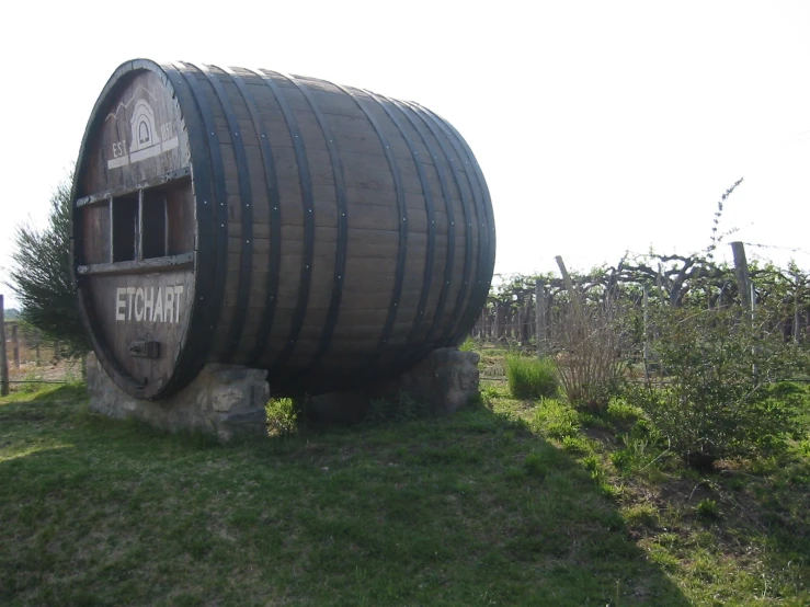 an old whiskey barrel in the middle of a field