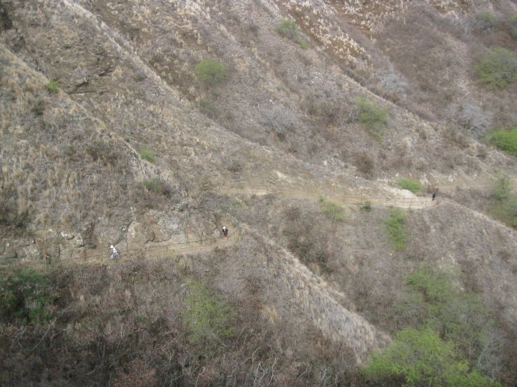 two people are hiking along a dirt path