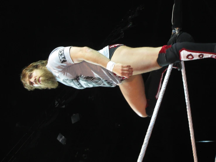 a man standing on top of a metal pole in shorts