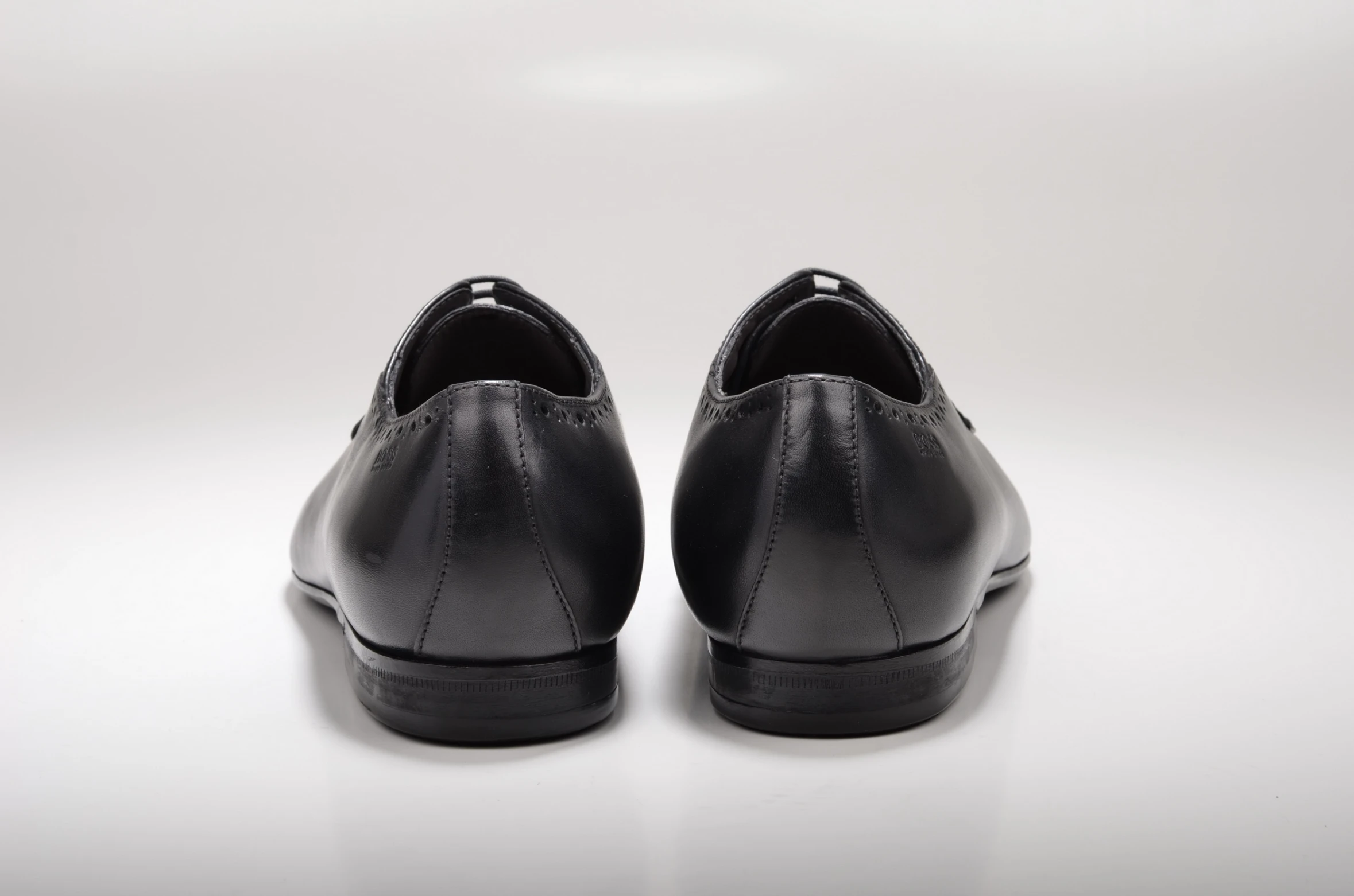 a pair of black men's shoes that are sitting on a white background