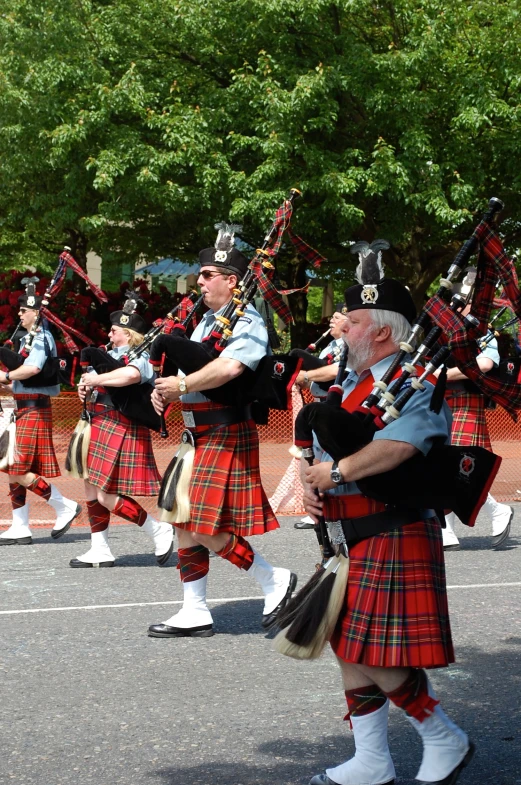 a group of men in kilts marching down a street