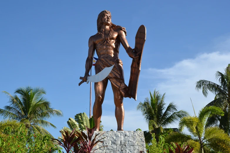 an old statue in the middle of a tropical tree