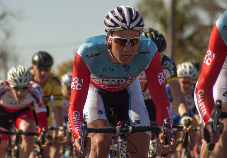 a person on a bike racing by with other bicyclists behind them