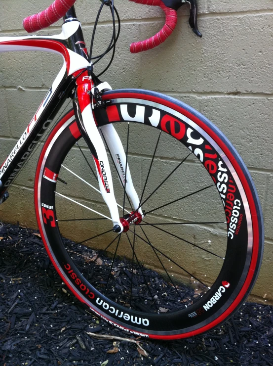 a bike sitting up against a building with a red and white wheel