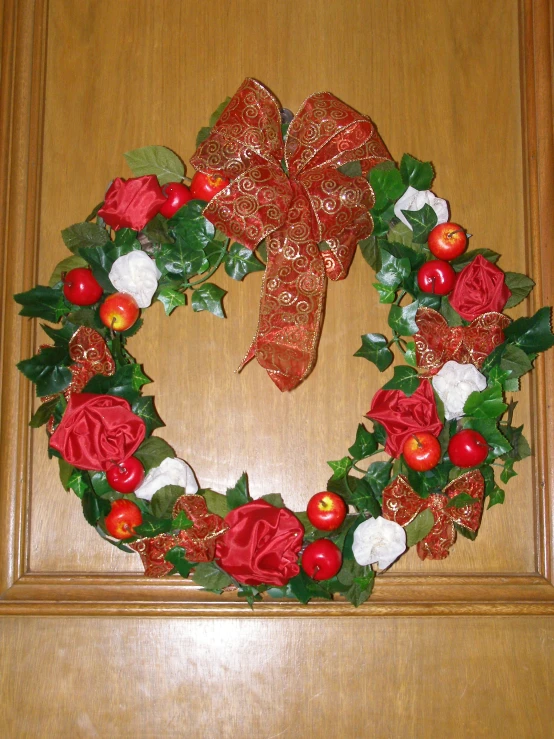 a wreath decorated with apples and flowers