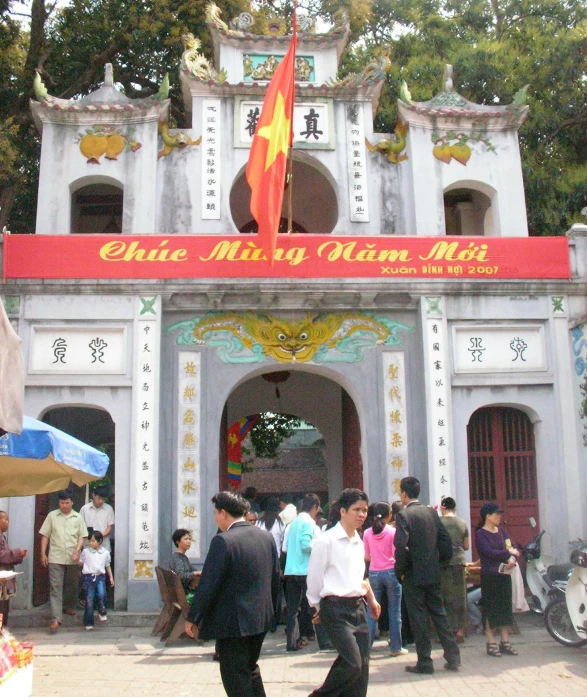 an asian shrine building with people walking around