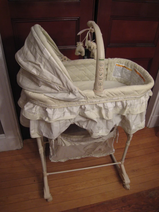 an infant cradle is on display on a wood floor