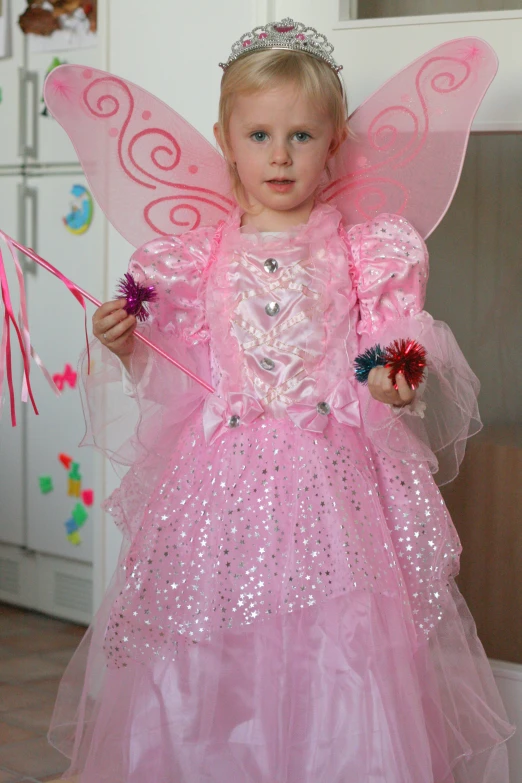 a little girl wearing pink and silver fairy costume