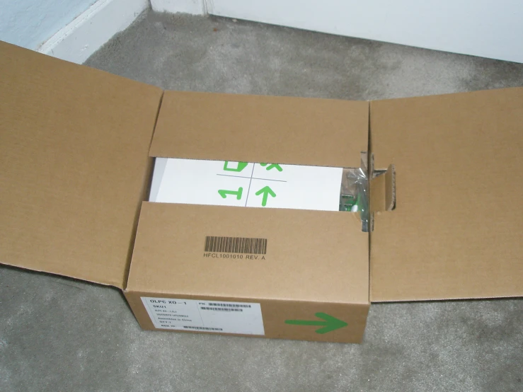 a cardboard box with an arrow is open on the floor