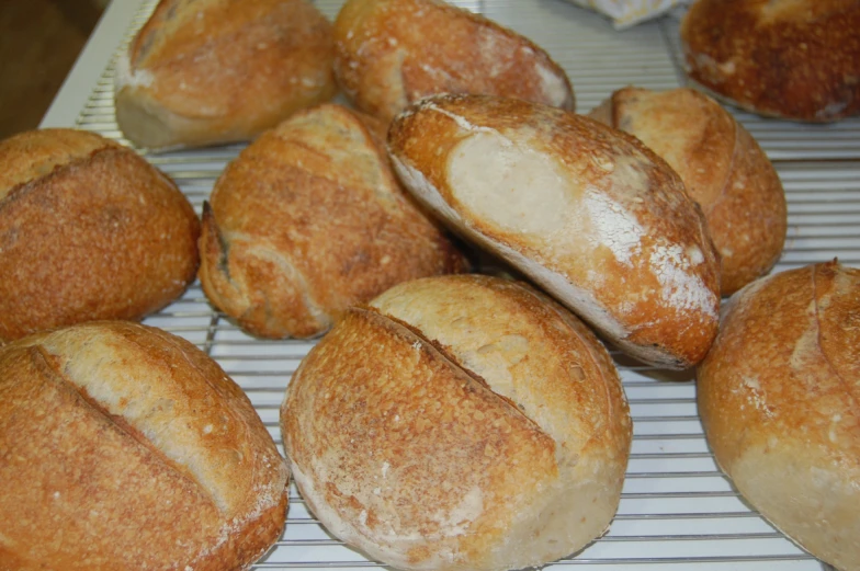 several round loaves of bread resting on a wire rack