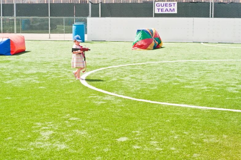 a little girl playing with a kite on a field