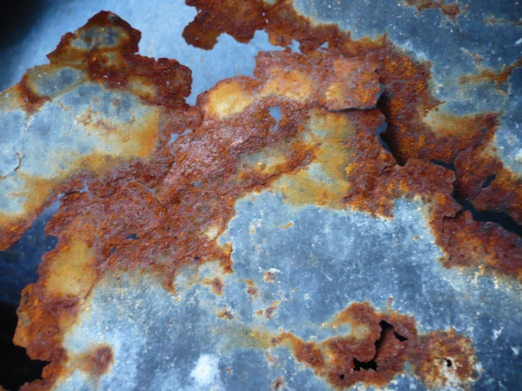 a rusty object laying in a blue and gray floor