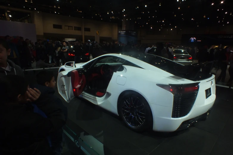 the rear of a white sport car at a show