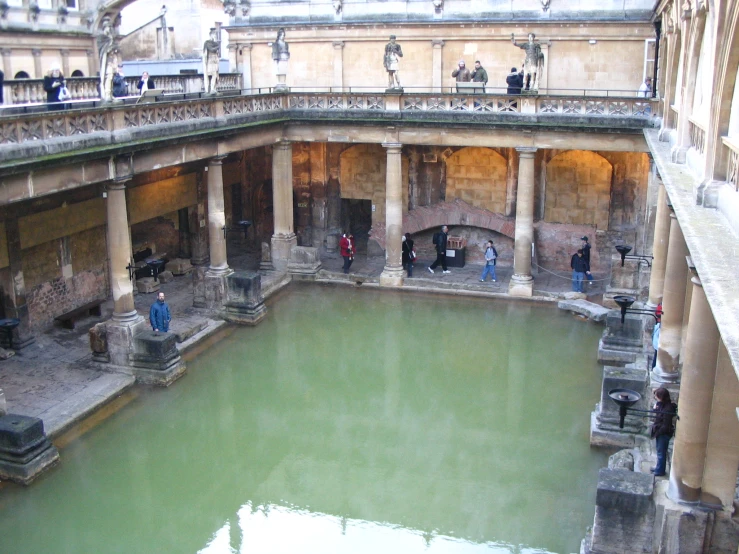 the people are standing inside an old, water - filled building