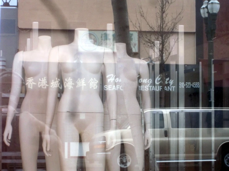 two mannequins behind glass in front of a store
