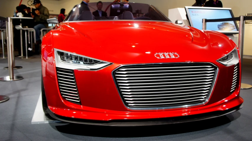 an audi sport car is shown in front of people