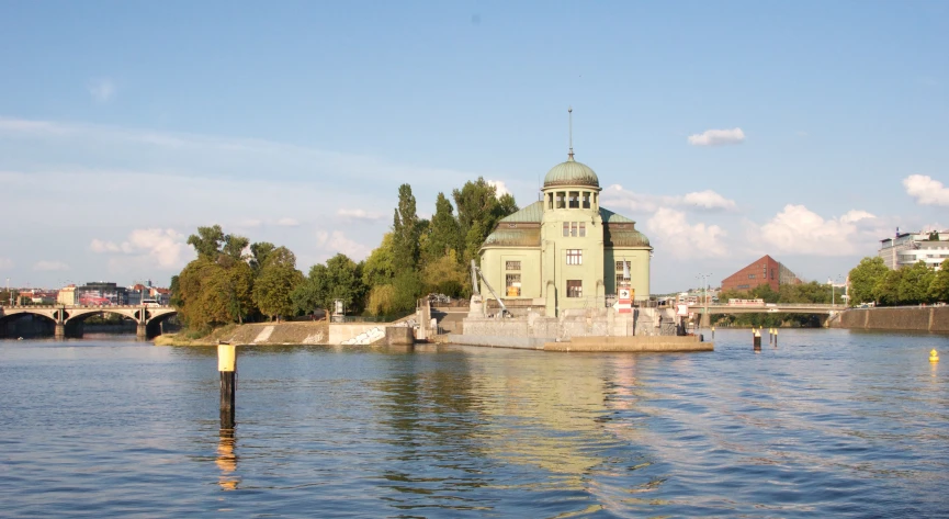 a house sitting on top of the water by a bridge