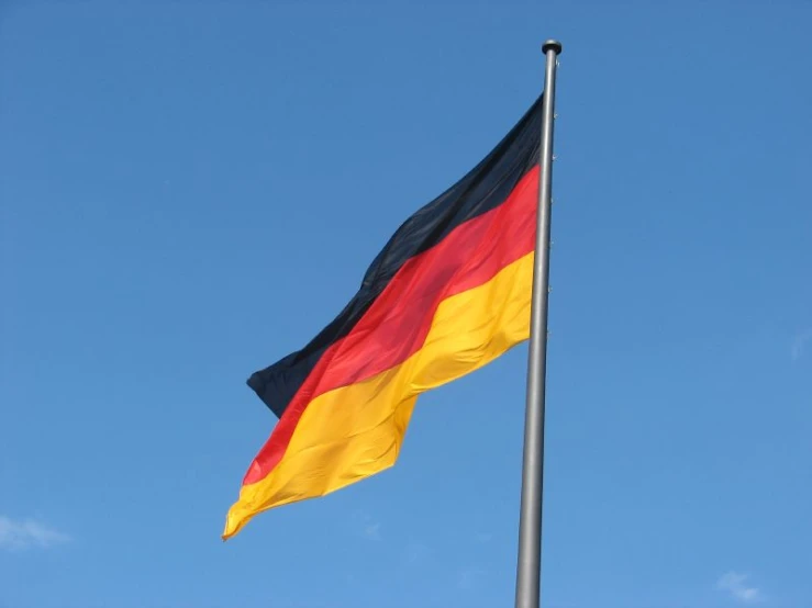 a flag flies in the air against a blue sky