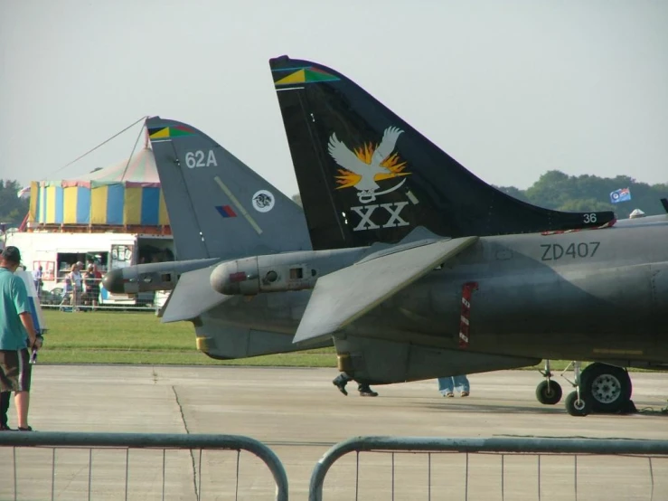 two military jets and a person in green shirts